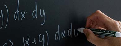 Image of Chalkboard, books, pencils in a cup and an apple.